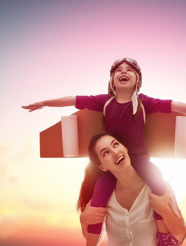 Mother and her child playing together. Little child girl plays astronaut. Child in an astronaut costume plays and dreams of becoming a spaceman. Happy loving family having fun.